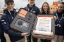 RNLI team of fundraisers, (not based in Lyme Regis, this is an RNLI  library pic) showing the historic scroll currently touring the UK