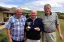CUP WINNER: Brian Fearon, centre, holding his trophies after winning the George Adams Cup, with veterans’ captain Roger Pollock, right, and a representative from the RNLI
