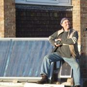 Bridport based Solar Thermal Specialist Jim Shearman next to solar panels