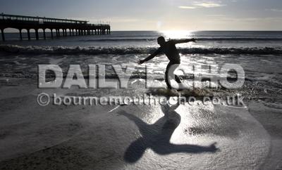 Skimming  on the beach at Boscombe on a sunny new Year's day