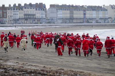 Weymouth annual santa run.   Running towards Bowleaze.  