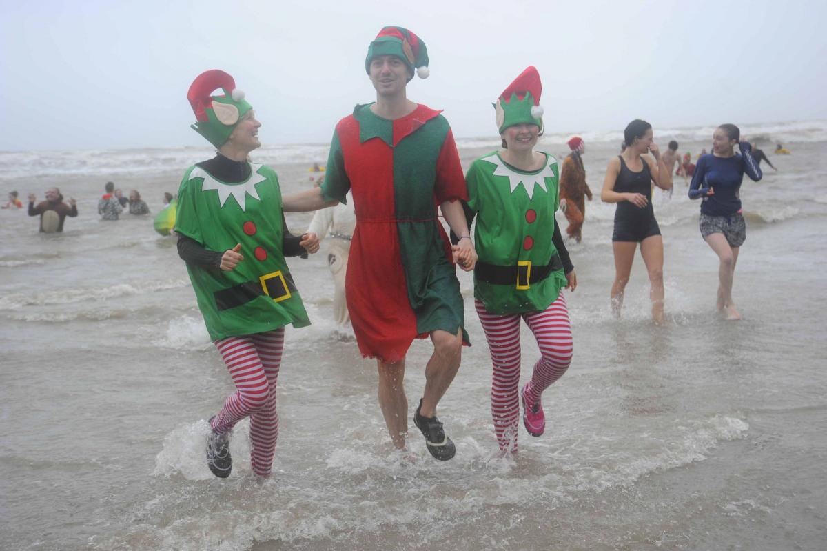 Swimmers coming back out of the sea at the Charmouth Christmas Day Swim 2015 Picture: Graham Hunt Photography