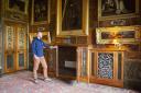 Undated handout photo issued by the National Trust of a staff member inspecting a mahogany and pietra dura mounted breakfront radiator cabinet in the Spanish Room, at Kingston Lacy, Dorset. One of the most opulent country houses in England has replaced