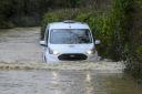 A van making its way through flooded roads near Burton Bradstock