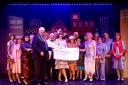 ALL DRESSED UP:  Cllr Owen Lovell presents a cheque to Lyme Regis Musical Theatre during a performance of Thoroughly Modern Millie