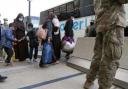 Families evacuated from Kabul, Afghanistan, walk through the terminal before boarding a bus  (AP Photo/Jose Luis Magana)