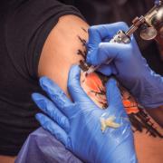 Tattooist working on professional tattoo machine device in a tattoo studio. Picture: PA