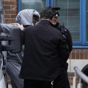 Mark Gordon is led into Crawley Police Station before being taken to Crawley Magistrates Court where he and Constance Marten are appearing charged with gross negligence manslaughter after the remains of a baby were found in an area of woodland.
