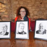 Sasha Slater with portraits of, from left,  Chris Sewell, John Eggleton and Tony Hawkins