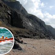 Emergency services were called as two people became stuck on the beach near Charmouth yesterday