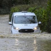 A van making its way through flooded roads near Burton Bradstock