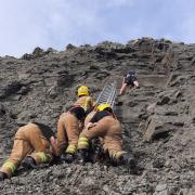 Firefighters rescuing a young man from a cliff face at Charmouth Beach