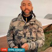 Alex Beresford delivering the ITV weather forecast from Eype