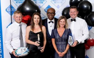 Staff at Bridport firm Heavers receive their award from former athlete Kriss Akabusi