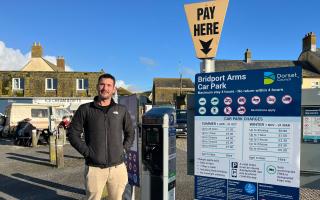 Tim Attrill, owner of Harbour Gifts in West Bay (in the background) at the car park outside his shop