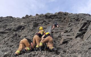 Firefighters rescuing a young man from a cliff face at Charmouth Beach